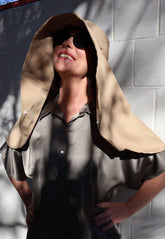 Woman wearing a beige Sun Safe hat that covers face and shoulders with sunglasses on.